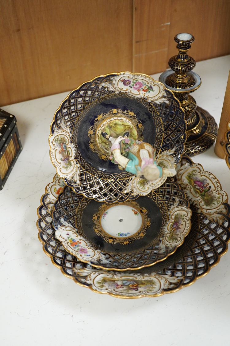 A pair of late 19th century Meissen three tier cake stands with figural tops, 48cm high